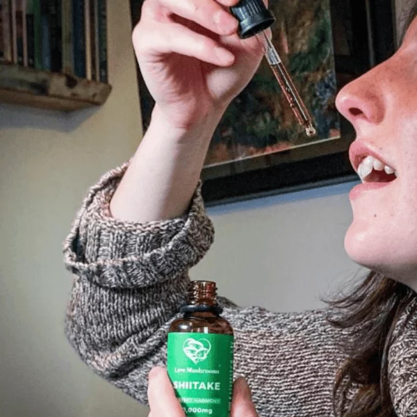 shiitake tincture woman taking drops