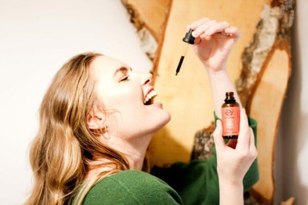 Woman takes chaga tincture, symbolizing incorporation of natural remedies into daily wellness routines.